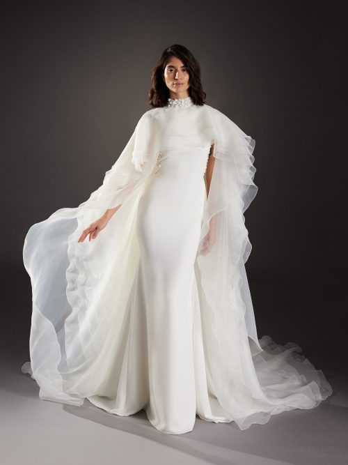 Afbeelding van de Atelier Pronovias Font trouwjurk met optionele cape en hoog gesloten halslijn, fit and flare stijl.