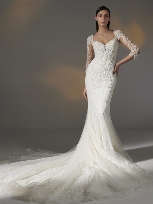 Bruidsjurk Pronovias Privée Hay in mermaid stijl met illusie halslijn, delicate kralen, kantwerk, transparante mouwen, en kathedraal sleep.