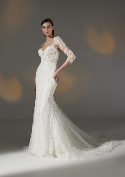 Bruidsjurk Pronovias Privée Hay in mermaid stijl met illusie halslijn, delicate kralen, kantwerk, transparante mouwen, en kathedraal sleep.