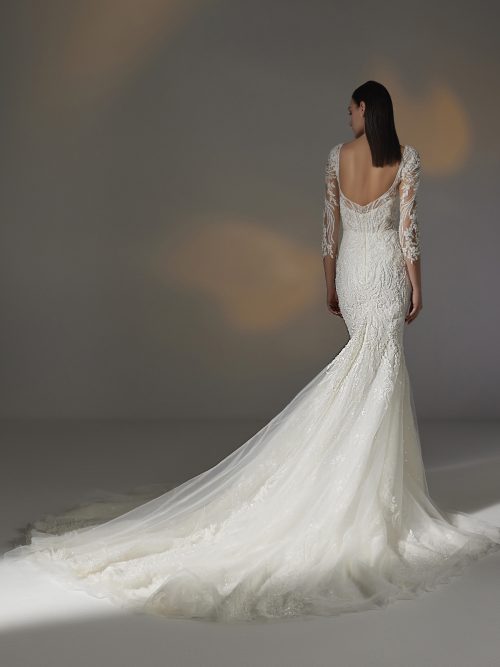 Bruidsjurk Pronovias Privée Hay in mermaid stijl met illusie halslijn, delicate kralen, kantwerk, transparante mouwen, en kathedraal sleep.