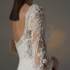 Bruidsjurk Pronovias Privée Hay in mermaid stijl met illusie halslijn, delicate kralen, kantwerk, transparante mouwen, en kathedraal sleep.