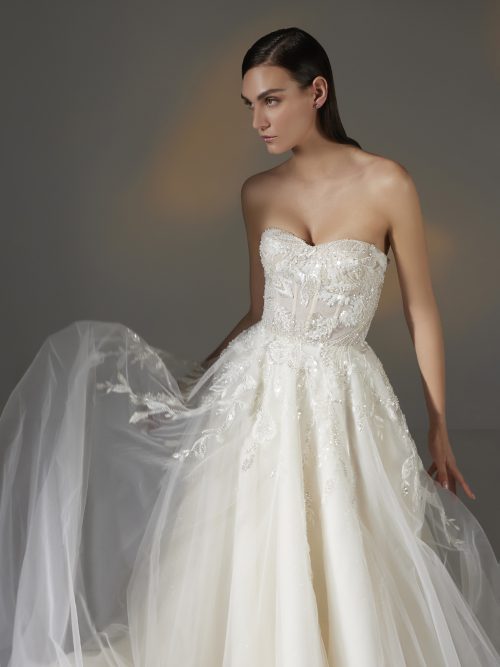 Marvely trouwjurk van Pronovias Privée, gekenmerkt door een strapless sweetheart top, bloemenkant details en een vloeiende A-lijn rok.