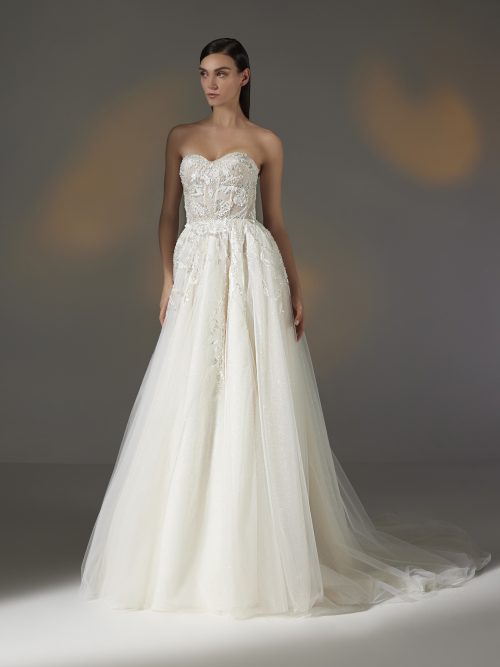 Strapless A-lijn trouwjurk van Pronovias Privée marvely, met een sweetheart halslijn, rijkelijk versierd met kralen en bloemenkant, afgewerkt met een sierlijke tule rok.