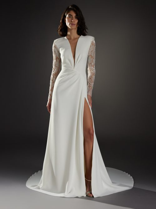 Afbeelding van de Atelier Pronovias Nouveau jurk met diepe V-hals en lange mouwen.