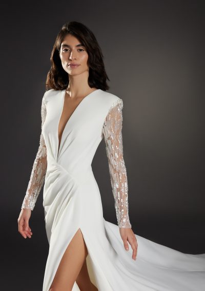 Zijaanzicht van de Atelier Pronovias Nouveau jurk met hoge split en vloeiende stof.