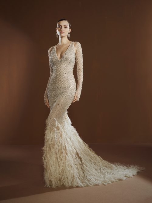 Model draagt de Elisabetta Franchi X Pronovias Queen Be trouwjurk met kristalversieringen en veren, vooraanzicht.