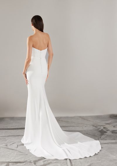 Achteraanzicht van de Pronovias Sincere trouwjurk met vloeiende crêpe stof en knoopsluiting.