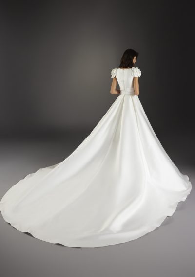 Achteraanzicht van de Atelier Pronovias Vella-jurk, toont de hoog gesloten rug en lange kathedraal sleep.