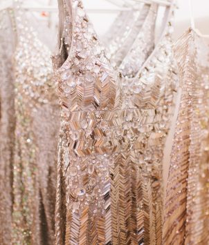 Beige sparkling dresses hanging in a wardrobe