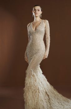 Model draagt de Elisabetta Franchi X Pronovias Queen Be trouwjurk met kristalversieringen en veren, vooraanzicht.