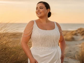 Curvy bruid in trouwjurk op het strand